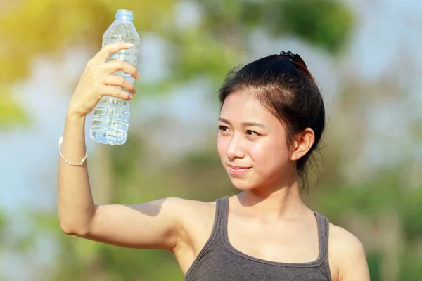 Femme sportive asia tenant et buvant de l'eau en plein air sur sunny da — Photo