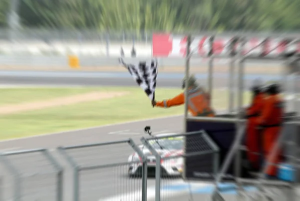 Blurry of Man sosteniendo y ondeando la bandera en el stand para la carrera — Foto de Stock