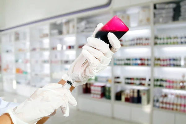 Jeringa de mano con guantes médicos con líquido rojo en la sangre y un — Foto de Stock