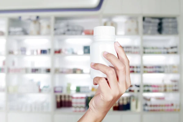 Ruka lékaře drží láhev medicíny v lékárničce a s — Stock fotografie