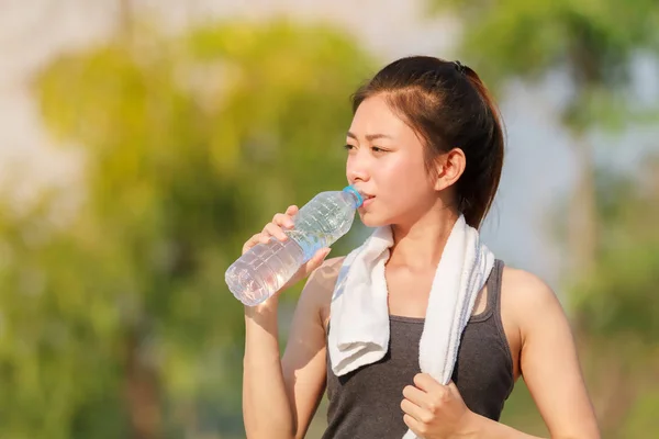 Femme sportive asie boire de l'eau en plein air le jour ensoleillé — Photo