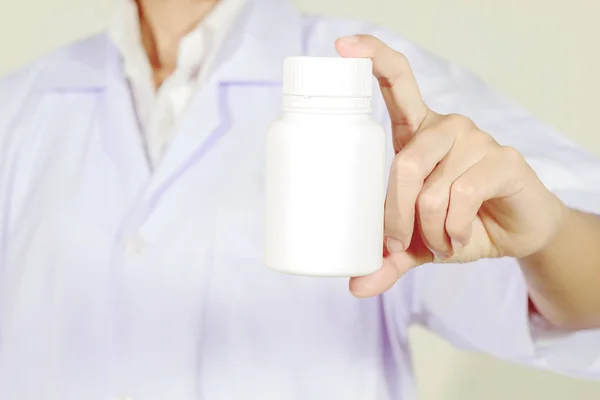 Mão do médico segurando frasco de medicamento no fundo branco — Fotografia de Stock