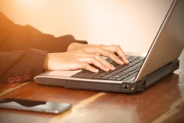 Händerna på affärskvinna på tangentbordet på hennes bärbara dator. — Stockfoto
