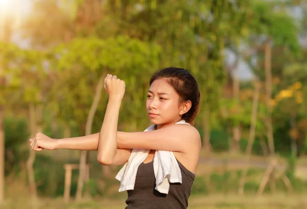 Atlética mujer asia calentamiento y joven atleta sentado —  Fotos de Stock