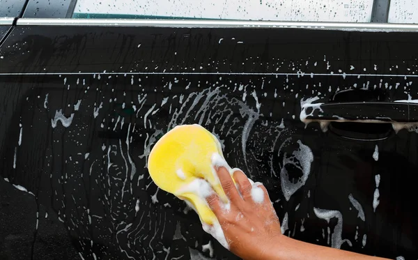 Man washing the car using the yellow sponge with foam . — Stock Photo, Image