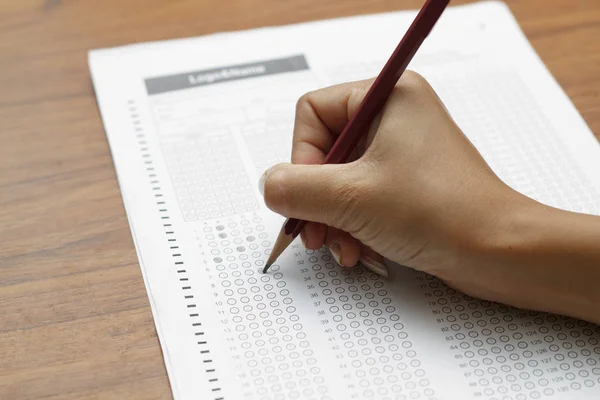 Hand av kvinnor innehar penna på standardiserade test form med answ — Stockfoto
