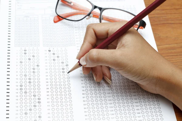 Hand av kvinnor innehar penna på standardiserade test form med answ — Stockfoto