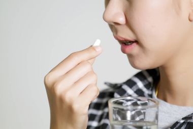 Asyalı kadınlar ilaçlar ve vitamin yardım hasta için alıyor ve 