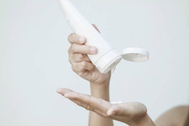 Güzel kadın Asya kullanarak bir cilt bakım ürünü, nemlendirici veya