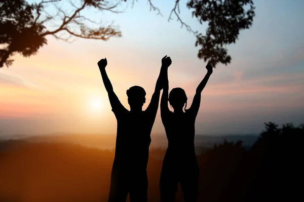 Silhouette of man and women show arm up for achievements success — Stock Photo, Image