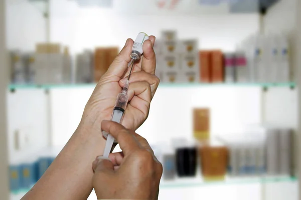 Руки доктора заполняют шприц на аптеке и фармацевтике — стоковое фото