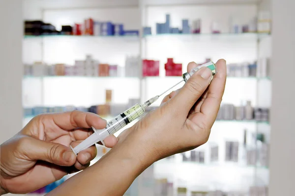 Manos a los médicos llenando una jeringa en la tienda de medicamentos y farmacia — Foto de Stock