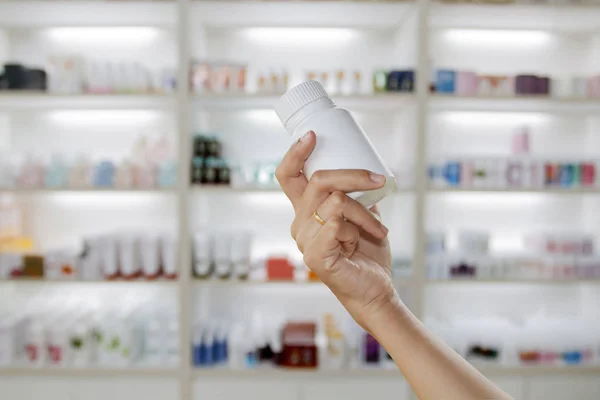 Mão de médico segurando frasco de medicina no armário de medicina e s — Fotografia de Stock