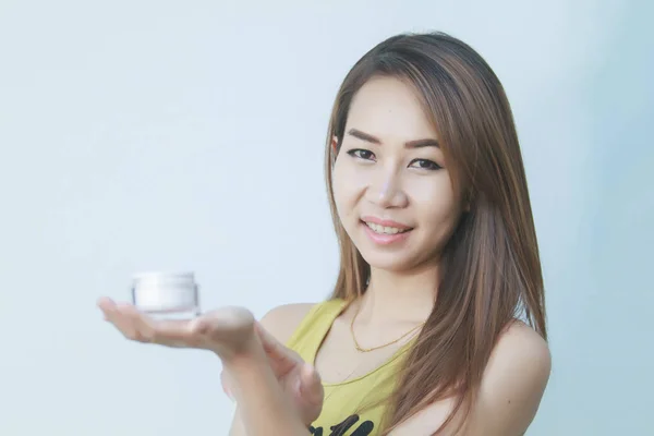Μια όμορφη γυναίκα Ασία χρησιμοποιώντας ένα προϊόν φροντίδας του δέρματος, ενυδατική κρέμα ή — Φωτογραφία Αρχείου