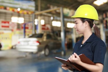 Genç kadın makinist bir araba teftiş gülümseyen portresi