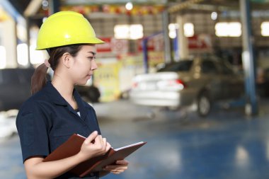 Genç kadın makinist bir araba teftiş gülümseyen portresi