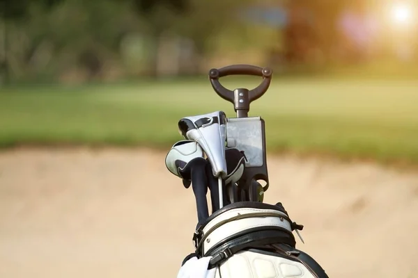 Golfový bag a profesionální golfové vybavení na golfovém hřišti při západu slunce — Stock fotografie