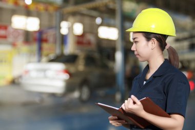 Genç kadın makinist bir araba teftiş gülümseyen portresi