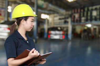 Genç kadın makinist bir araba teftiş gülümseyen portresi