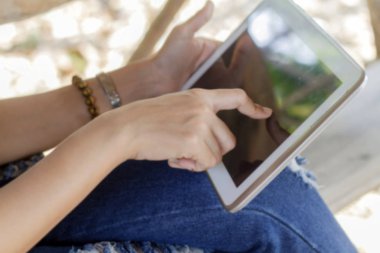 Asya kadın tablet, açık kullanma yakın zaman dinlenmek için