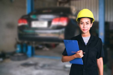 Genç kadın makinist bir araba teftiş gülümseyen portresi