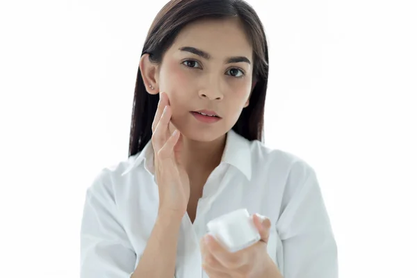 Μια όμορφη γυναίκα Ασίας χρησιμοποιώντας ένα προϊόν φροντίδας του δέρματος, ενυδατική κρέμα o — Φωτογραφία Αρχείου