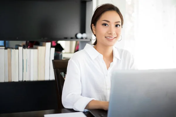 Asiático mulheres de negócios usando notebook e sorrindo feliz para worki — Fotografia de Stock
