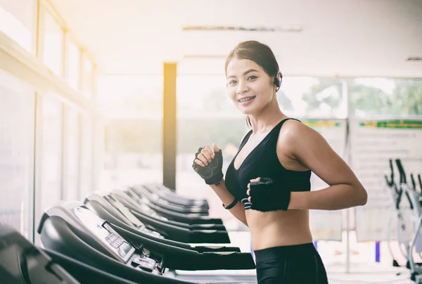 Aziatische vrouwen lopen en joggen op de loopband in de sportschool — Stockfoto