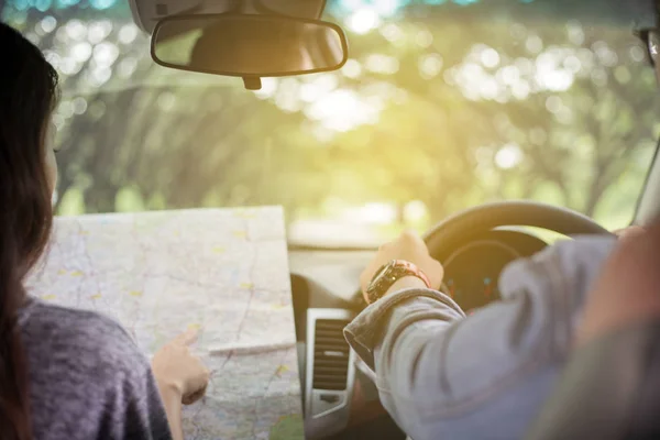 Asian man and woman using map on roadtrip and Happy young couple