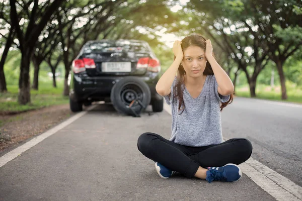 Mujeres estresadas sentadas después de un accidente automovilístico con triángulo rojo o — Foto de Stock