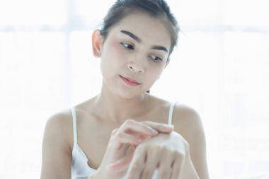 Güzel bir kadın bir cilt bakım ürünü, nemlendirici o kullanarak Asya