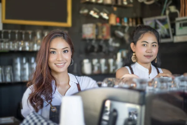 Азіатські жінки Barista посміхається і за допомогою кавомашину в s кави — стокове фото