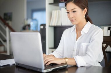 Not Defteri kullanarak ve çalışırdı için mutlu gülümseyerek Asya iş kadınları