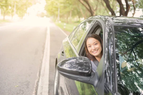 Hermosa mujer asiática sonriendo y disfrutando.conducir un coche en la carretera —  Fotos de Stock
