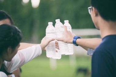 Asya grup öğrenci tutan ve vurmak su şişe cam üzerinde