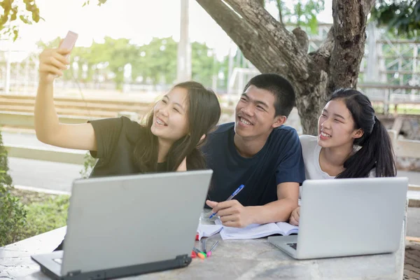 Asiático grupo de estudiantes sonriendo y selfie con amigo — Foto de Stock