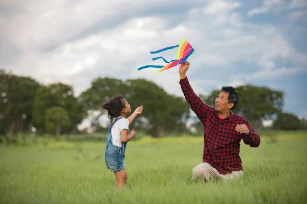 Aziatische kind meisje en vader met een vlieger uitgevoerd en gelukkig op mea — Stockfoto