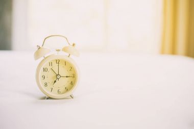 Beyaz yatakta analog çalar saat, saat sabah bir geminin subaylarınca ile