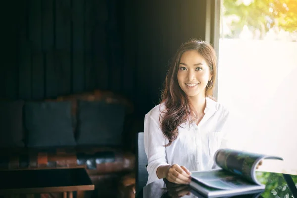 Mujeres asiáticas sonriendo y leyendo un libro para relajarse en el café —  Fotos de Stock