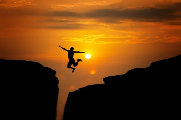 Silhouette of man travel jump up for achievements successful and — Stock Photo, Image