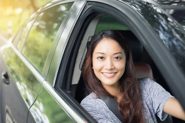 Hermosa mujer asiática sonriendo y disfrutando.conducir un coche en la carretera —  Fotos de Stock