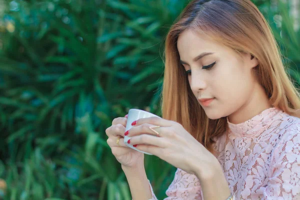 Asiática mulher de negócios está trabalhando e bebendo café ao ar livre — Fotografia de Stock