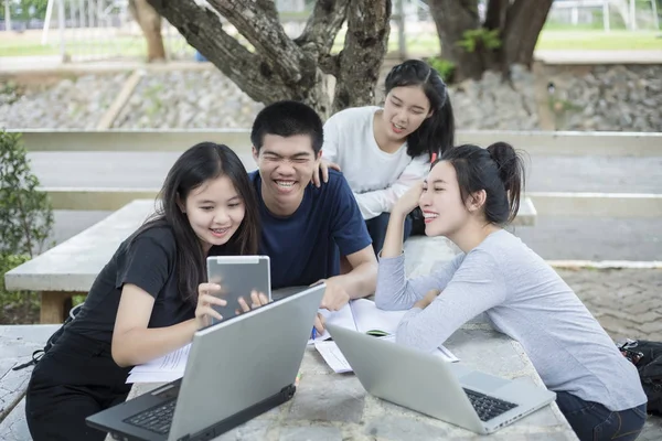 Grupo Asiático de estudiantes que usan tabletas y portátiles compartiendo con t — Foto de Stock