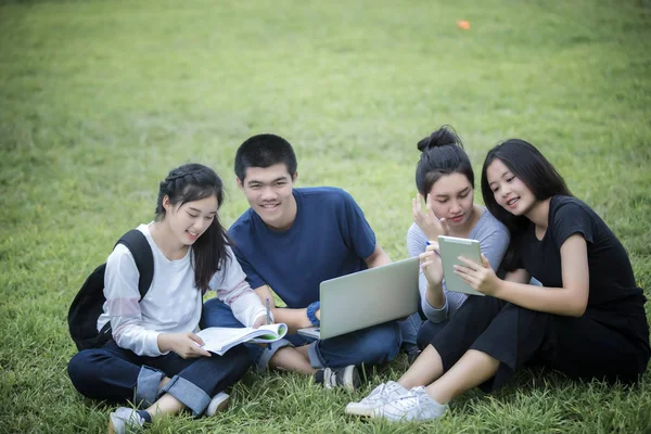 Grupo Asiático de estudiantes que usan tabletas y portátiles compartiendo con t — Foto de Stock