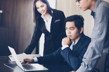 Asyalı işadamları ve iş ortakları için dizüstü kullanarak grubu