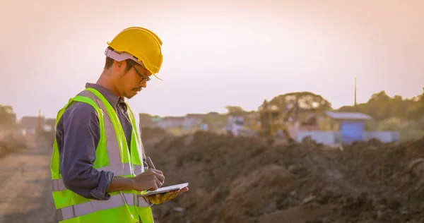 Aziatische ingenieur met veiligheidshelm met behulp van tablet pc computer inspecteren — Stockfoto