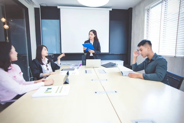 Empresarios asiáticos y grupo utilizando cuaderno para conocer a un serio —  Fotos de Stock