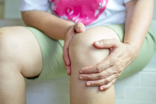 Enfoque suave de las viejas mujeres asiáticas a lesión de rodilla — Foto de Stock