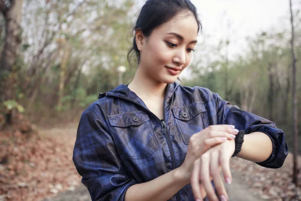 Läuferin checkt Fitness-Tracker der Smart Watch und lächelt — Stockfoto