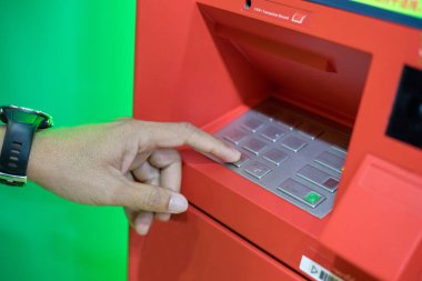 Atm/banka makine tuş takımında pin/pass kodunu girerek adam yardım